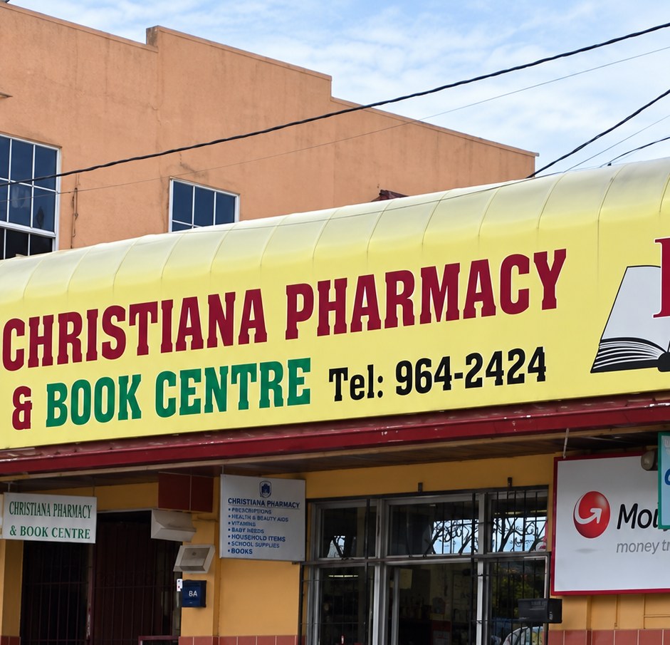 Christiana Pharmacy & Book Centre storefront with its yellow, red and green signboard on Main Street, Christiana, Manchester, Jamaica